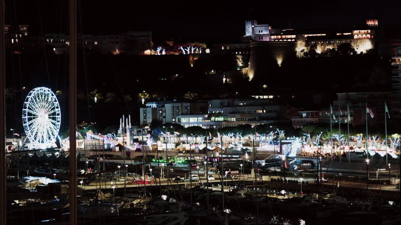 Distant view of an illuminated Ferris Wheel at Port Hercule Funfair in Monaco at night