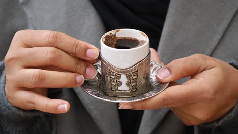 woman holding a cup of turkish coffee