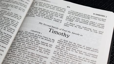 close up shot of bible page turning to the book of second timothy