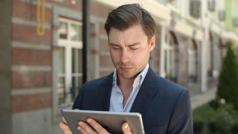 closeup man holding modern touchpad at street. man browsing internet on tablet