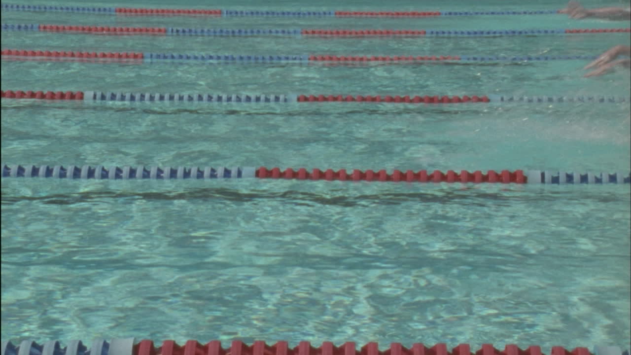 A group of men race to the other side of the pool