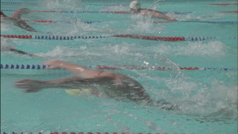 a group of men race to the other side of the pool