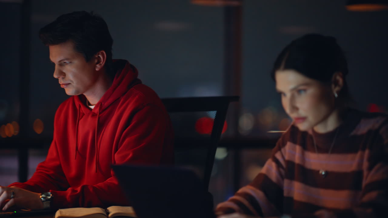 People working on laptops at night