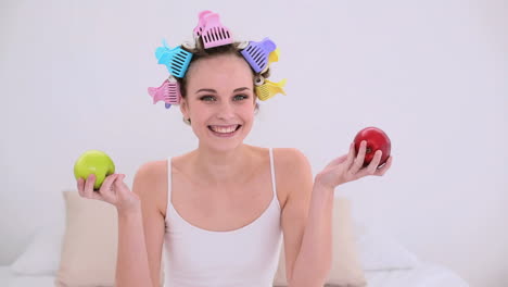 Young-model-in-hair-rollers-holding-red-and-green-apples