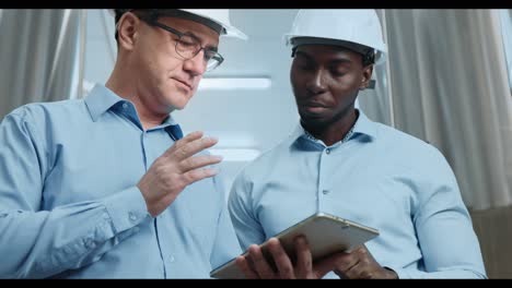 engineers reviewing data on a tablet in a brewery