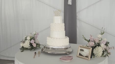 front view of the wedding cake with accompanying flowers, cutlery and photo