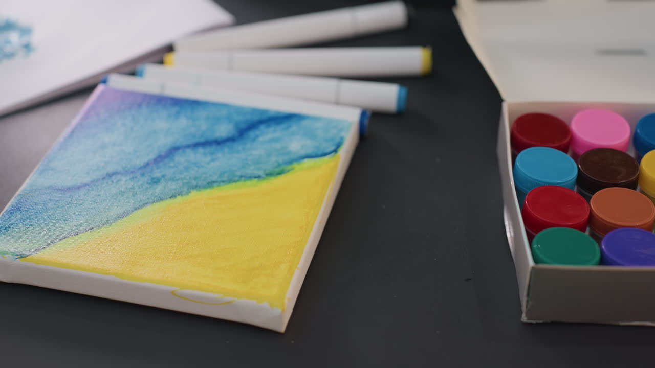 lienzo pequeño con una vista serena del océano con lavados brillantes y rotuladores, paisaje marino compacto en acuarela sobre un lienzo pequeño que muestra un paisaje costero apacible con lavados coloridos y material artístico