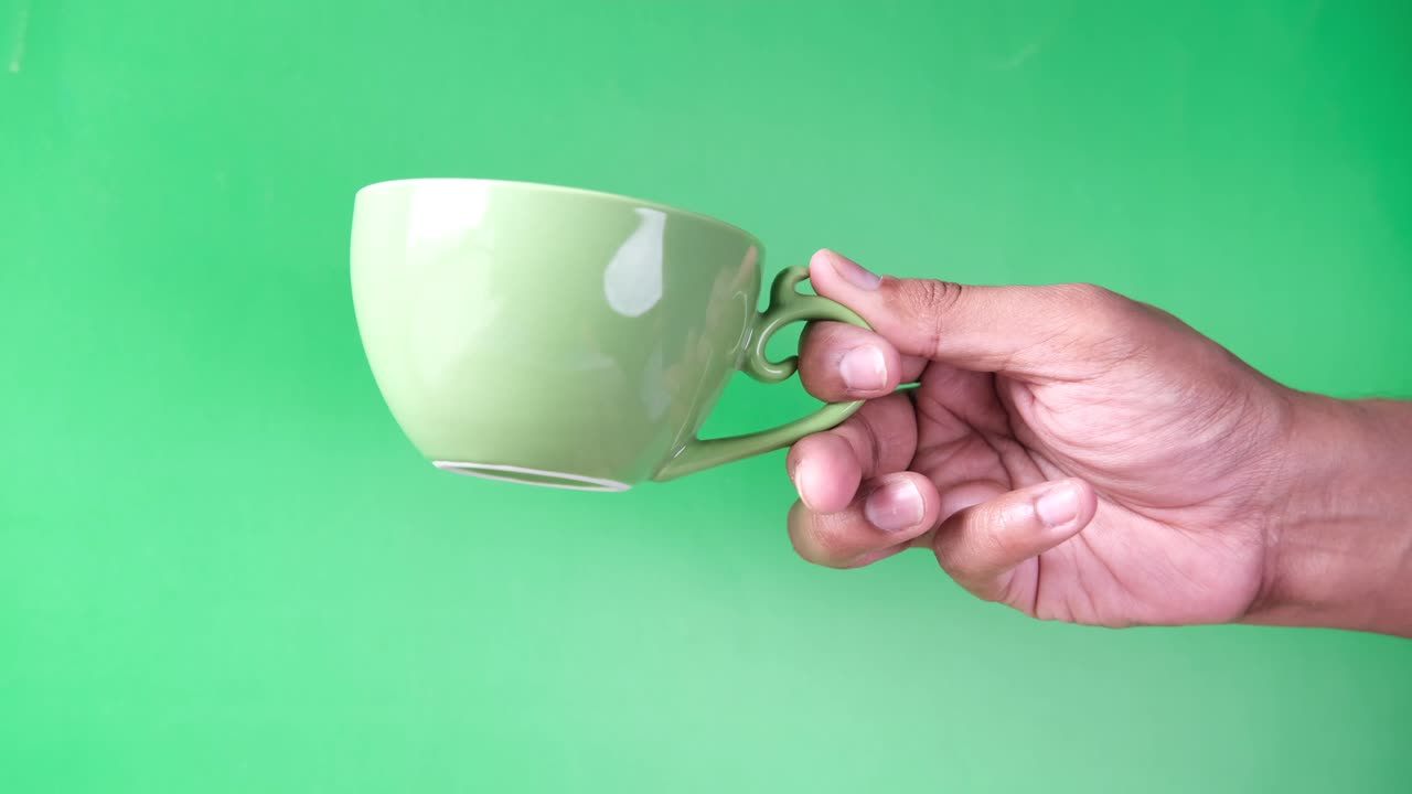 mano sosteniendo una taza de café verde claro
