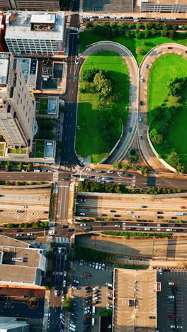 busy traffic by the roads, bridges and roundabouts of philadelphia, pennsylvania, usa. city panorama from aerial view. vertical video