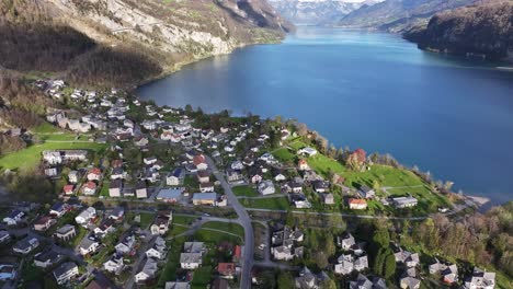 Luftaufnahme-Von-Weesen,-Schweiz,-Mit-Charmanten-Häusern-Entlang-Der-Ufer-Des-Schimmernden-Walensees,-Eingerahmt-Von-Grünen-Hügeln