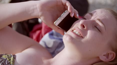 señorita sentada en la playa mientras usa su dispositivo móvil 9