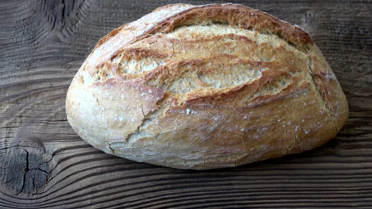 Delicious freshly baked bread on wooden background.