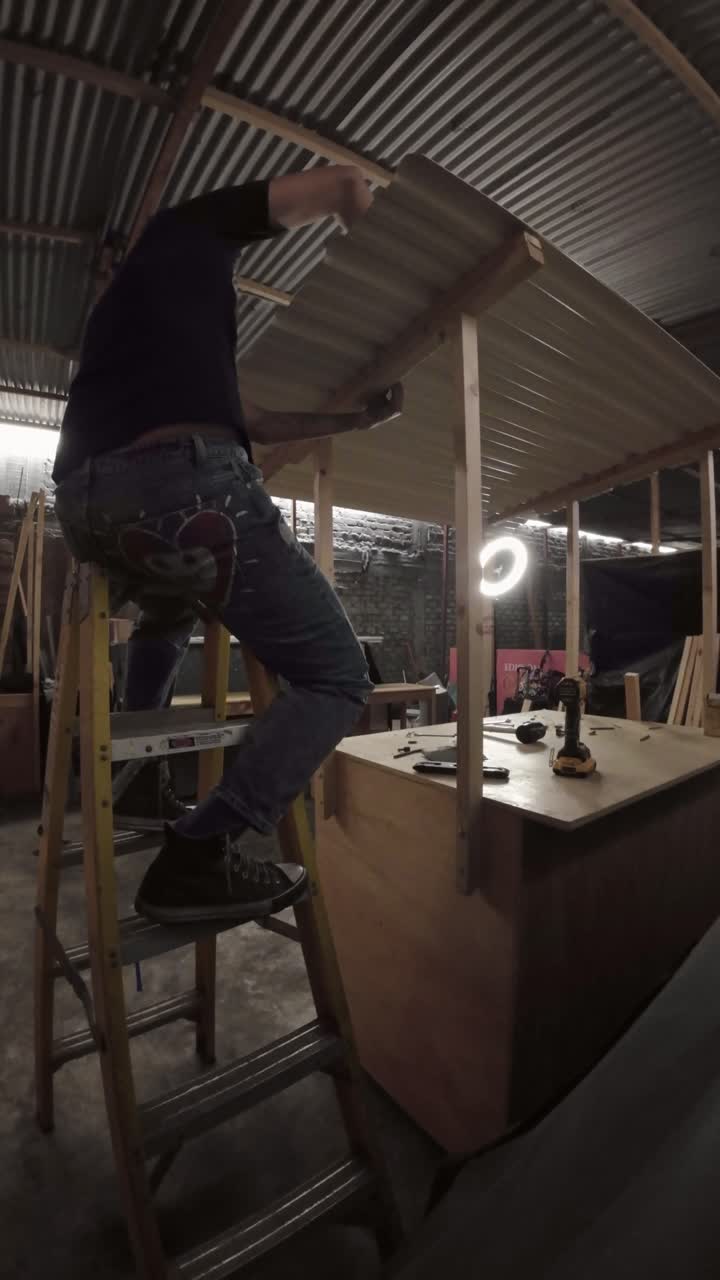 Uomo che costruisce un box in legno con tetto in lamiera ondulata in officina