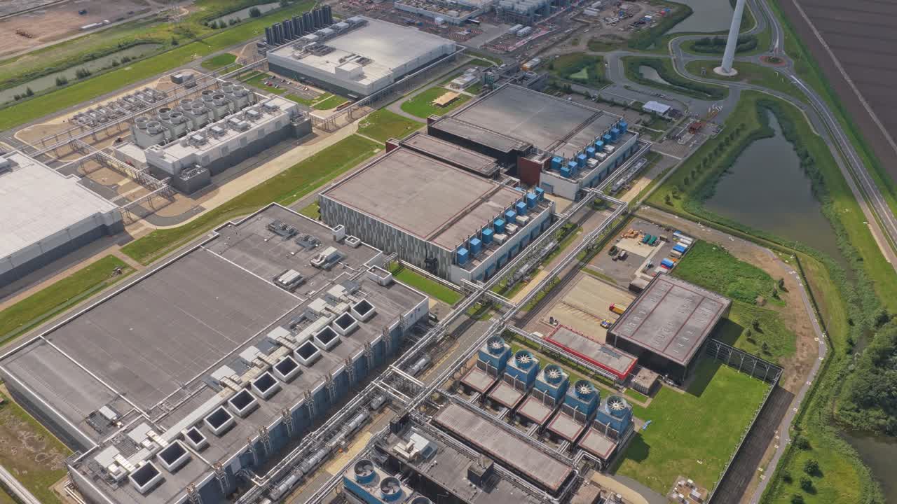 Luftfoto af digitalt datacenteranlæg, køletårne og IT-systemer.