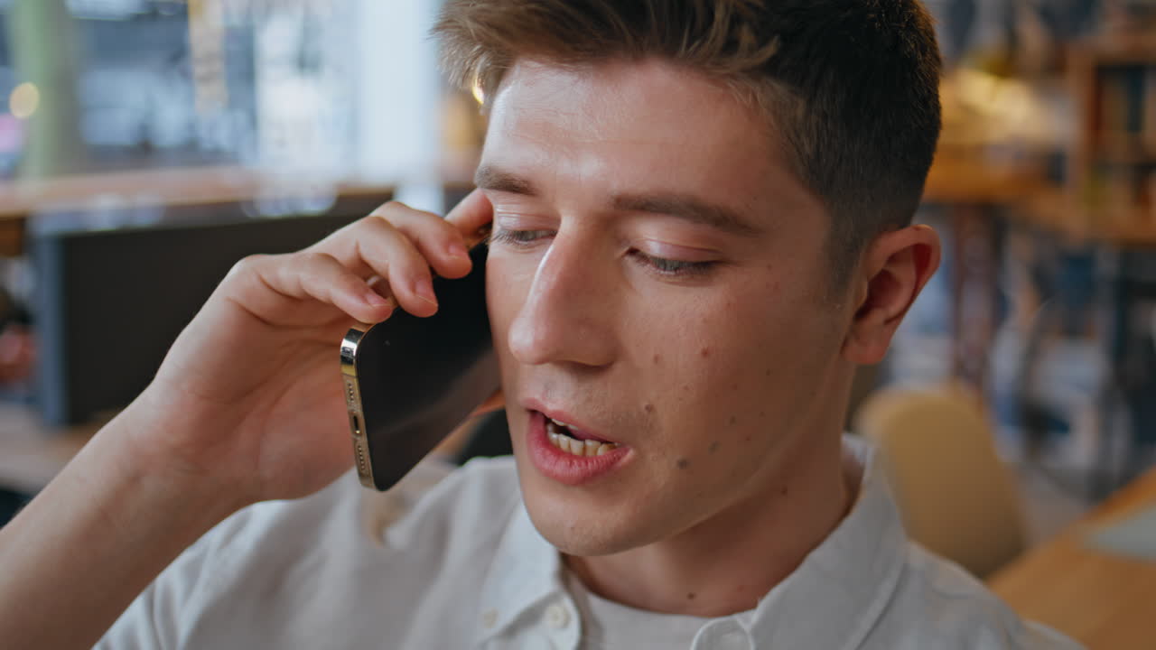 Relaxed coworker smartphone call speaking office closeup. Man mobile phone chat