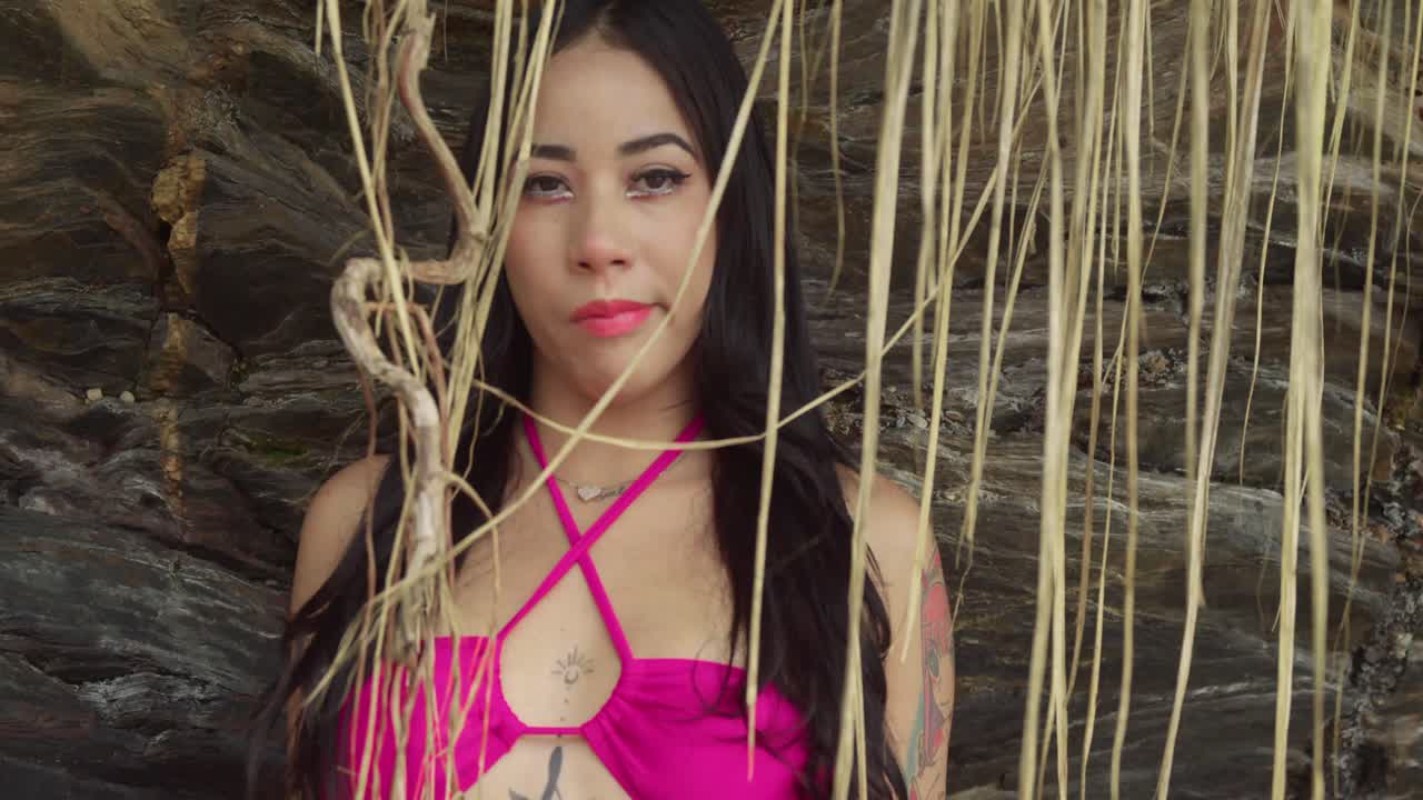 numa praia de uma ilha tropical em trinidad, uma rapariga hispânica de biquíni rosa absorve o sol