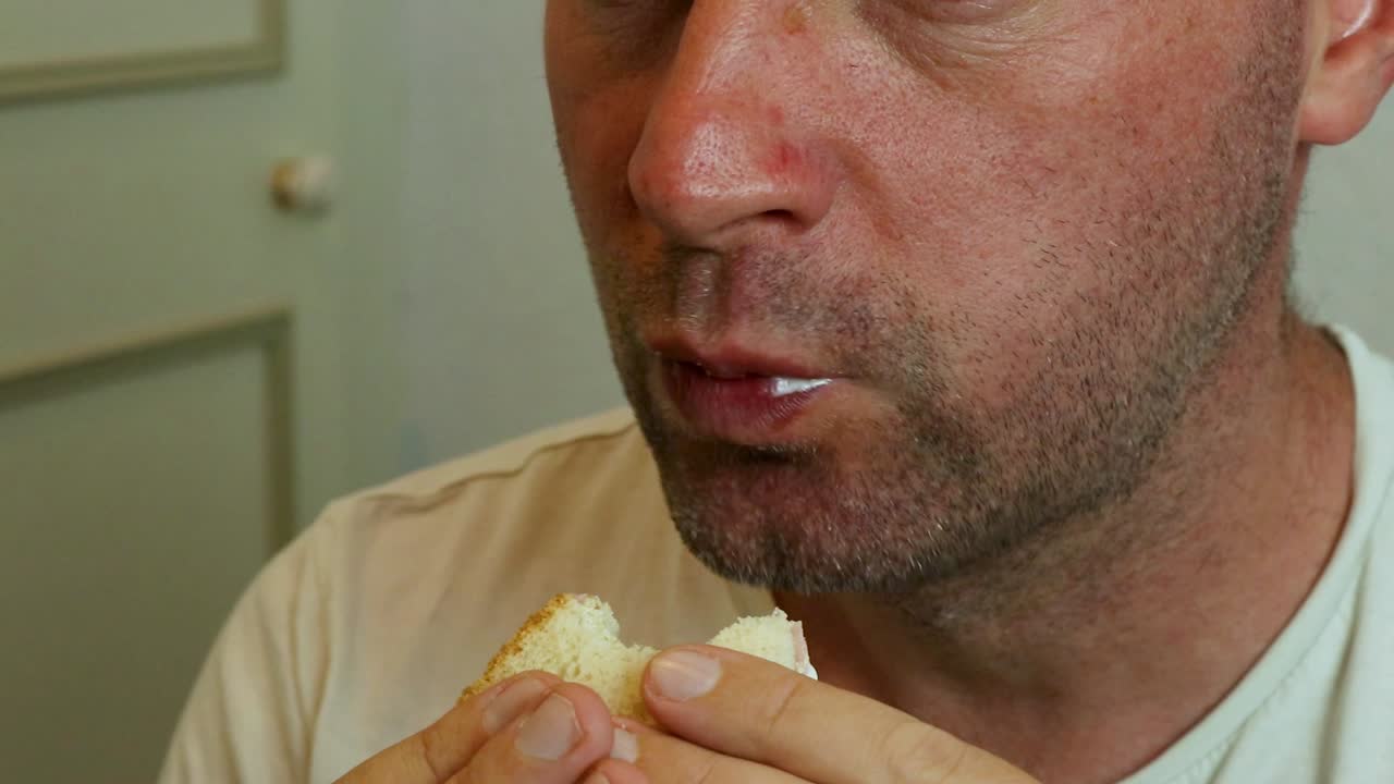 un hombre comiendo un sándwich de cerca