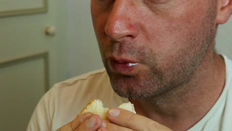 a man eating a sandwich close up