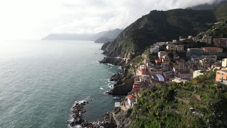 riomaggiore cinque terre italy aerial static view of village as waves crash into shore