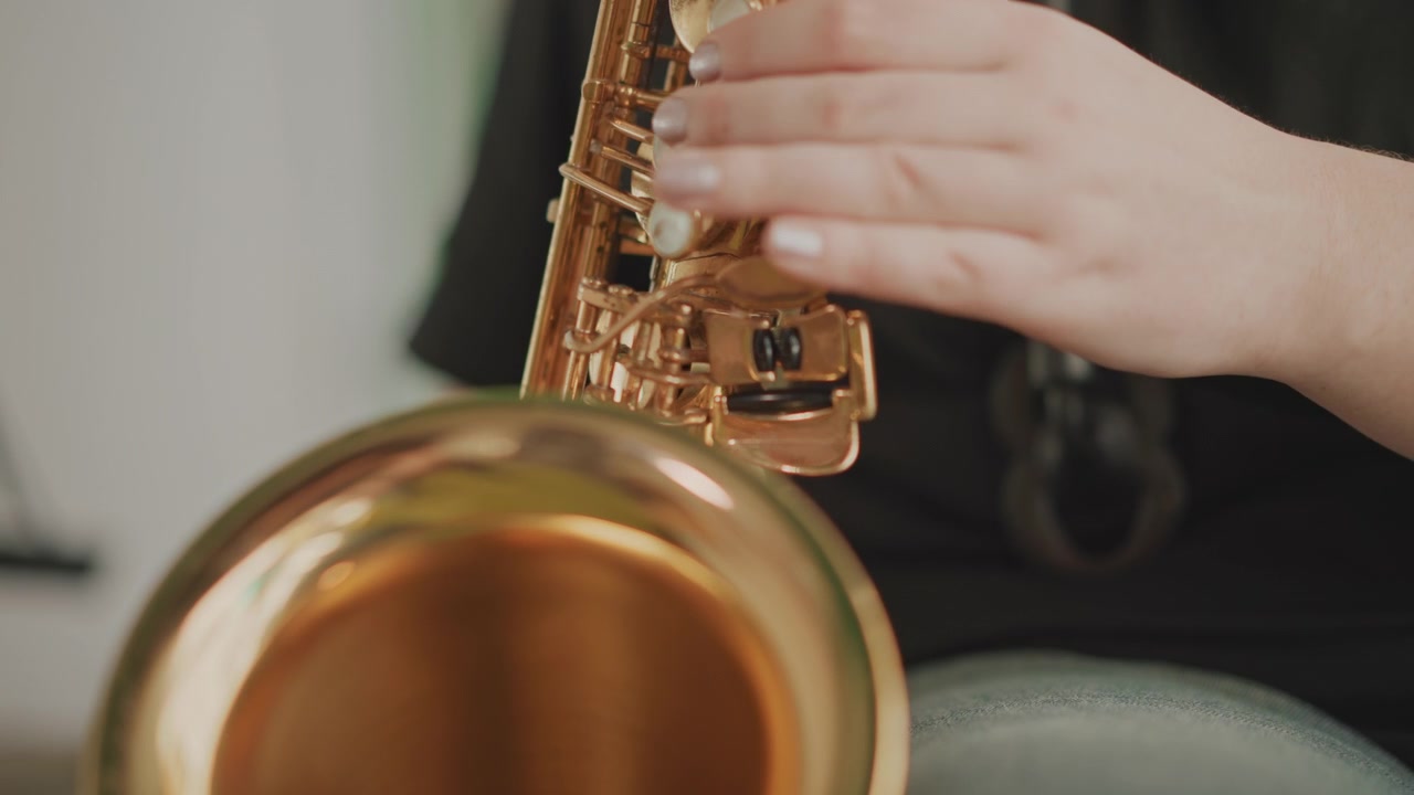 School lesson featuring bell saxophone performance. Student demonstrating technique and tone with bell saxophone. Warmtoned bell saxophone being played during classroom music practice by student