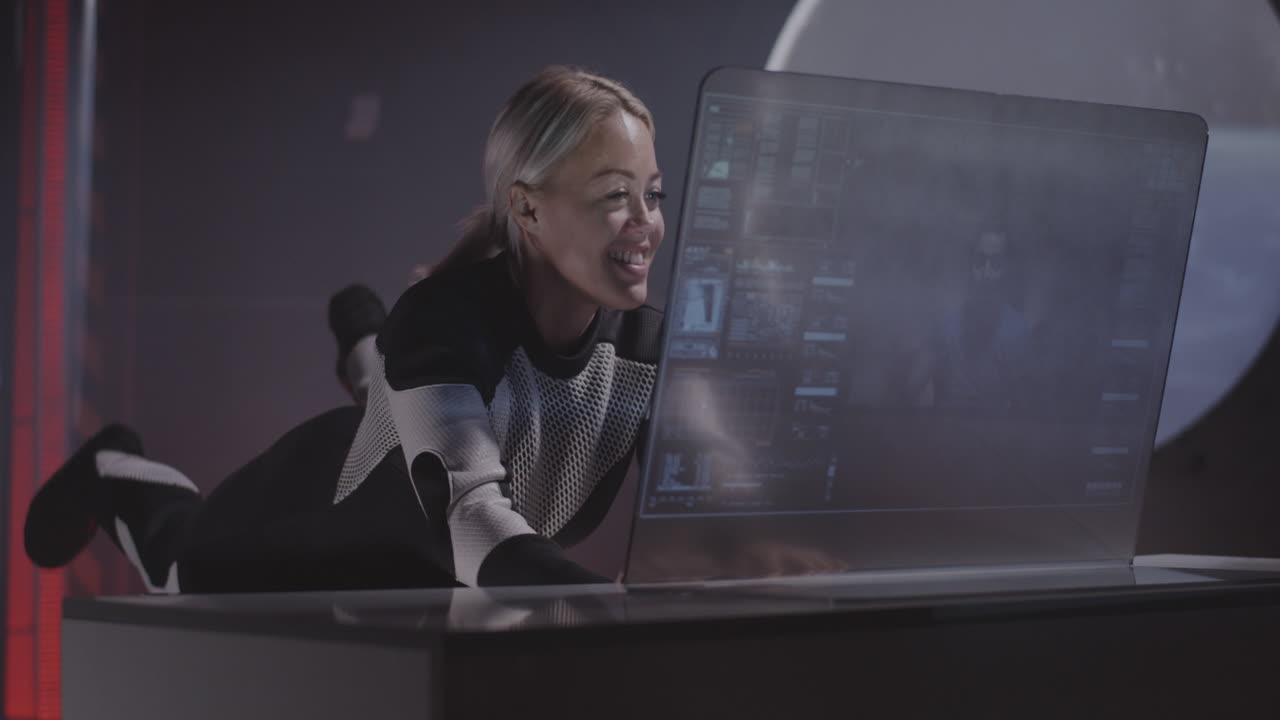 Woman in Spacesuit Excitedly Using Futuristic Laptop