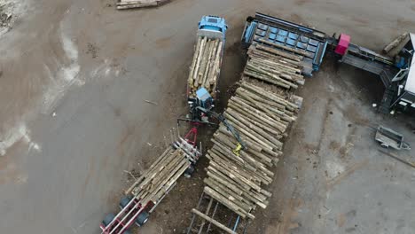 camión de madera cargando madera de un remolque en suecia