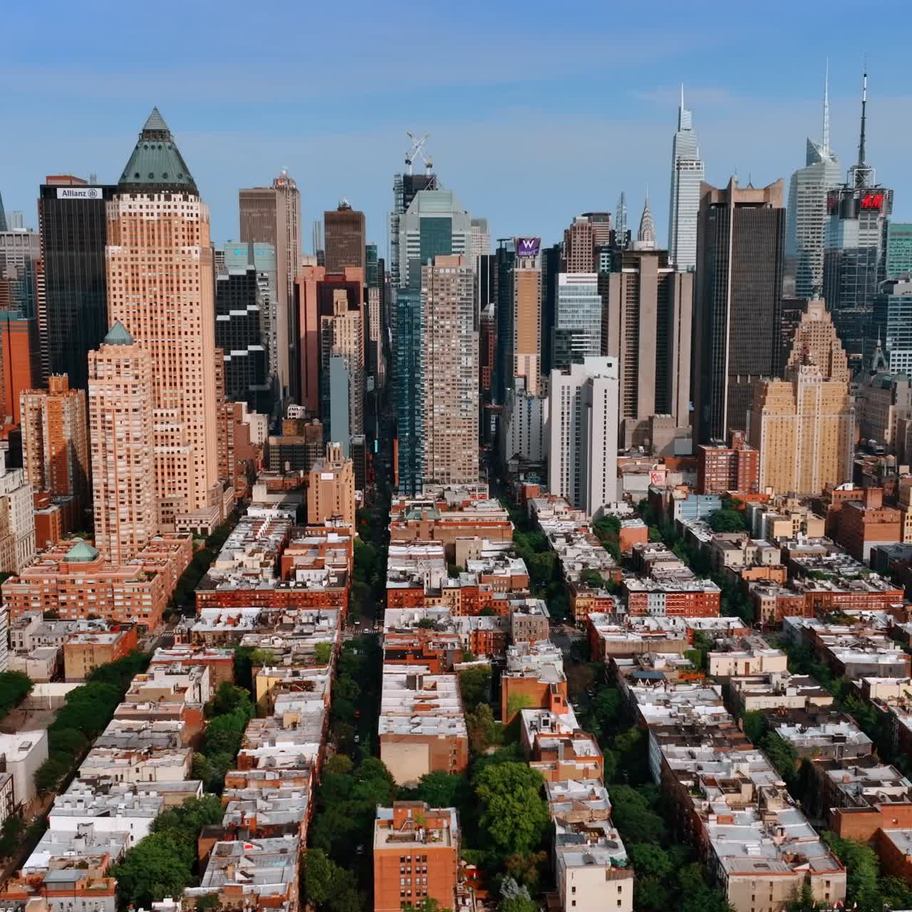 Green area with residential houses of few storeys at the backdrop of skyscrapers. New York cityscape from drone footage on sunny day