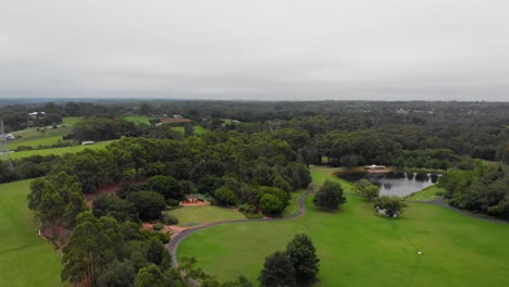 Aerial-view-of-a-parkland,-with-lots-of-open-grass-areas-and-trees