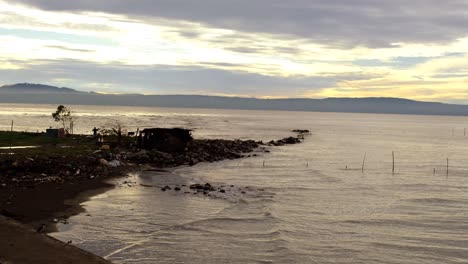 Seaside-full-of-plastic-and-other-garbage-materials-next-to-a-cottage