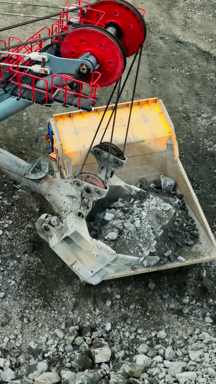 Excavator Loading Rocks into Dump Truck at Mining Site