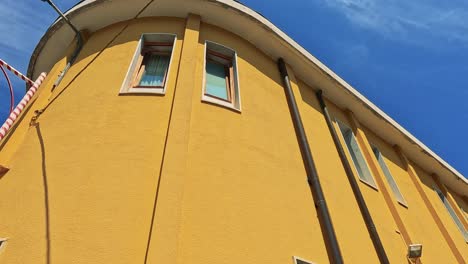 yellow building facade with a hanging sign