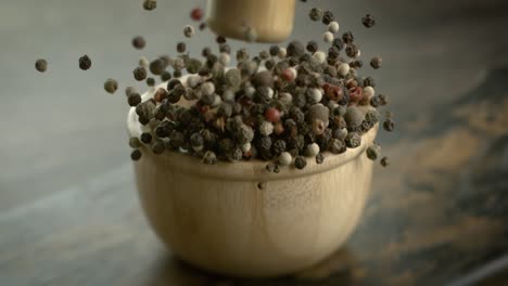 mixed peppercorns in a super slow motion. dry mix peppercorns close up.