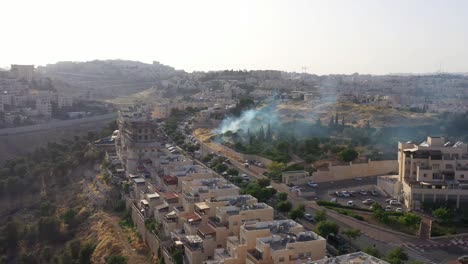 smoke rising in jewsih neighbourhood near palestine border-aerial