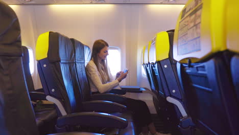 mujer usando teléfono inteligente en el avión
