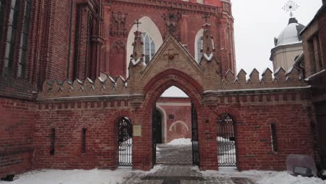 red brick church entrance to courtyard dolly in walking shot in winter with snow covering the ground