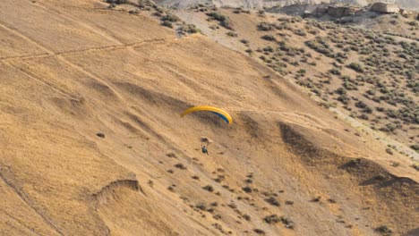 Un-Parapente-Flota-Sobre-El-Paisaje-Del-Desierto-De-Montaña---Cámara-Lenta