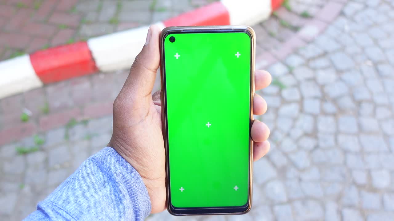 mano sosteniendo un teléfono inteligente con una pantalla verde