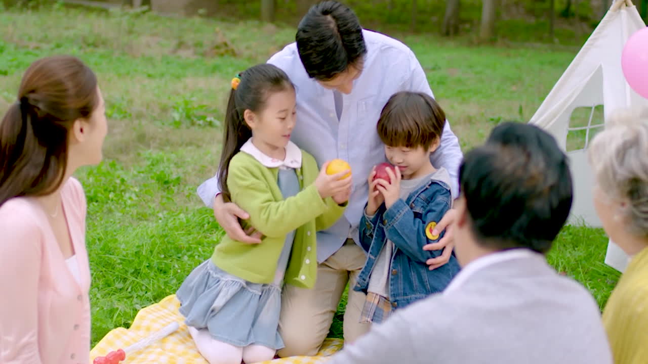 부모와 아이들은 가을 공원에서 야외에서 가족과 함께 놀고 있습니다.