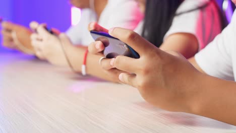 hands of asian esport team gamers playing in competitive video games on a cyber games tournament by mobile phone