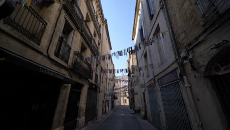 narrow streets with little flags closed shops france montpellier lockdown