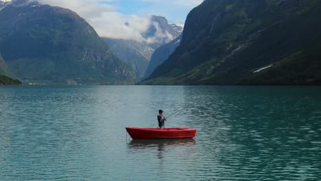 Una-Mujer-En-El-Barco-Pesca-Un-Pez-Girando-En-Noruega.