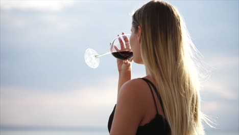 mujer disfrutando de un vaso de vino rojo al aire libre