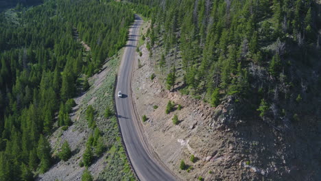 Weißes-Auto,-Das-Auf-Einer-Straße-Durch-Einen-Wald-Der-Colorado-bergkette-Fährt