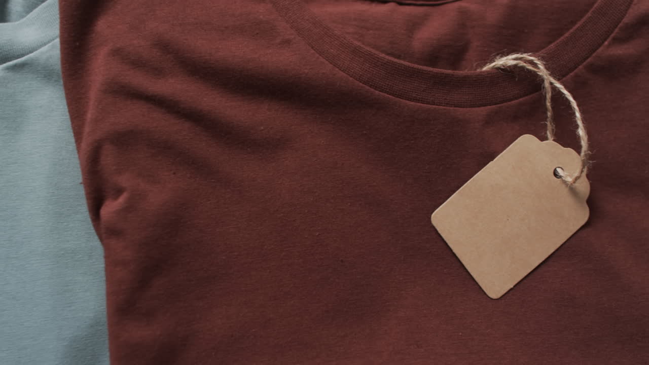 video di un lay piatto di magliette multicolori con etichette e spazio di copia su sfondo bianco