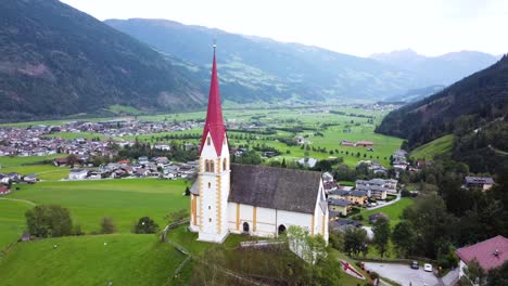 torre de la iglesia con vistas a una aldea de valle extensa rodeada de montañas