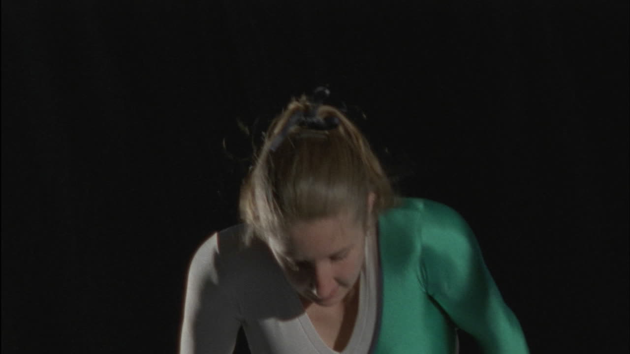 체조 선수가 고르지 않은 막대에서 수행