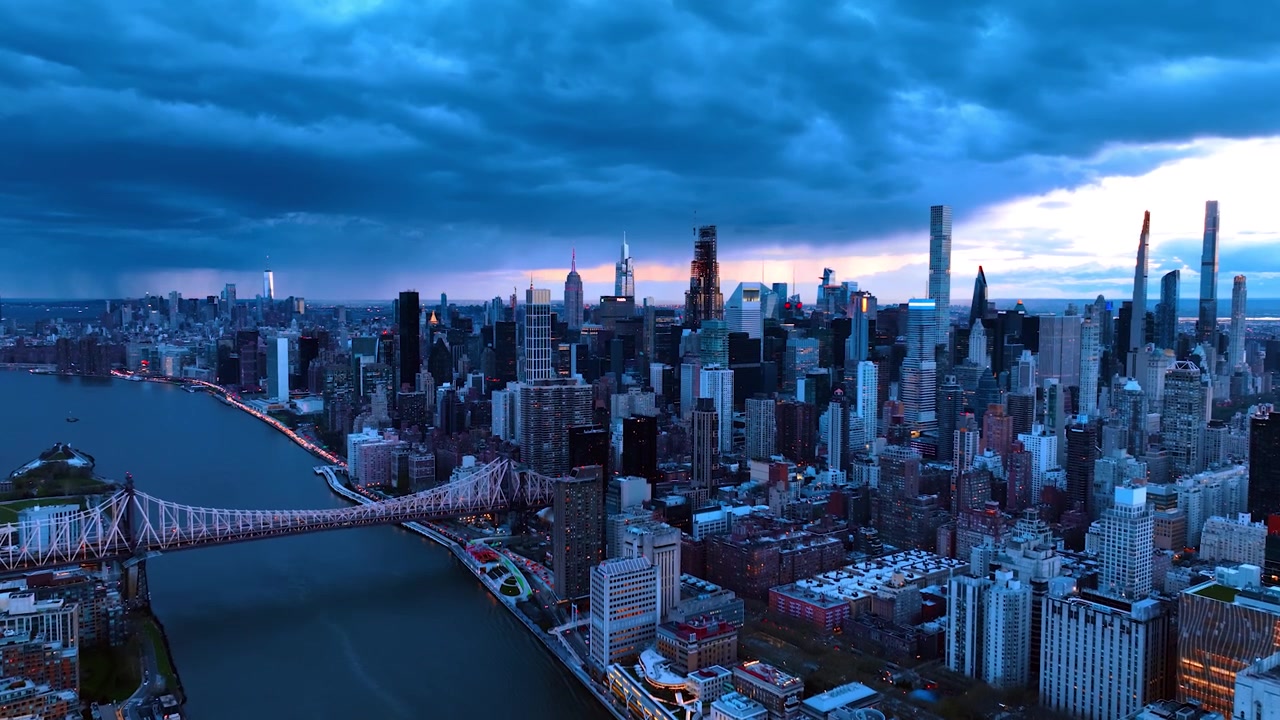 Riprese drone che si elevano sopra l'East River a New York. Bellissimo scenario della metropoli americana al crepuscolo