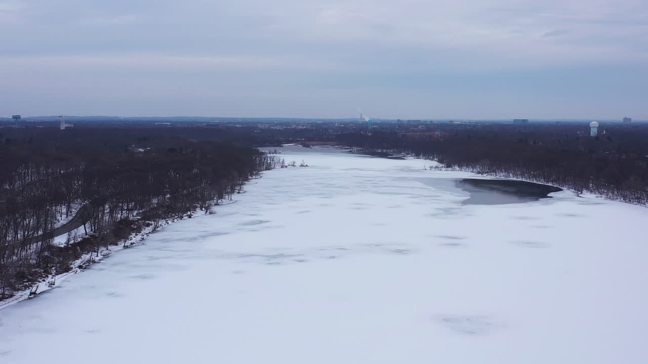 흐린 일출 동안 길고 넓은 호수 위에 무인 항공기의 공중 보기