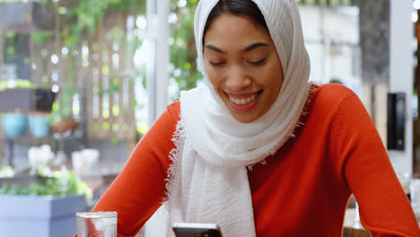 Woman-using-mobile-phone-in-cafeteria-4k