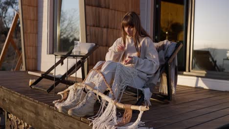 woman crafting macrame on a cottage deck